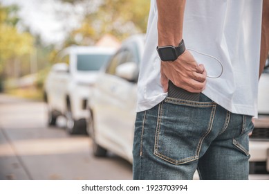 young man holding a cell phone in the back pocket of his pants