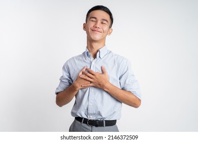 young man holding chest feeling relieve and comforting himself