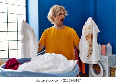 Young Man Holding Clean White T Shirt And T Shirt With Dirty Stain Angry And Mad Screaming Frustrated And Furious, Shouting With Anger. Rage And Aggressive Concept. 