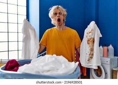 Young Man Holding Clean White T Shirt And T Shirt With Dirty Stain Afraid And Shocked With Surprise And Amazed Expression, Fear And Excited Face. 