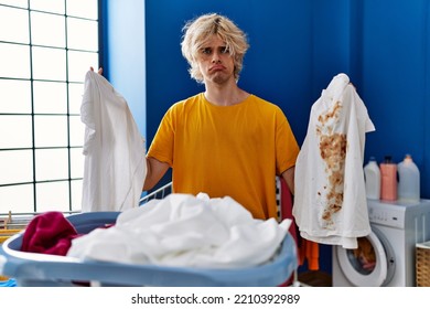 Young Man Holding Clean White T Shirt And T Shirt With Dirty Stain Depressed And Worry For Distress, Crying Angry And Afraid. Sad Expression. 