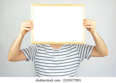 Young Man Holding Cork Pinboard In Front Of His Face With Five Pinned Paper, Copy Space, Isolated On White Background, Paper Area For Text On Wooden Cork Board, Banner Idea, 