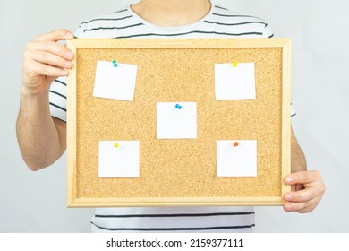 Young Man Holding Cork Pinboard With Five Pinned Paper, Copy Space, Isolated On White Background, Paper Area For Text On Wooden Cork Board, Banner Idea, 