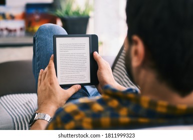 Young Man Holding Ereader und Reading E-Book