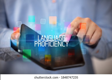 Young man holding a foldable smartphone with LANGUAGE PROFICIENCY inscription, educational concept - Shutterstock ID 1848747235