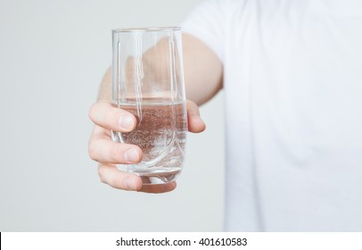 Young man holding a glass with water, closeup shot - Shutterstock ID 401610583