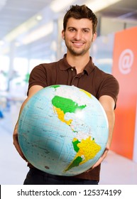 Young Man Holding Globe, Indoors