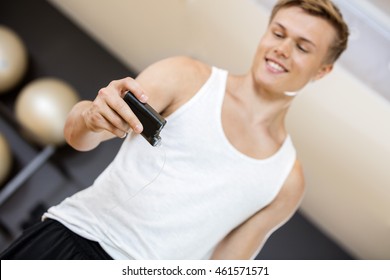 Young Man Holding Glucose Monitor In Gym