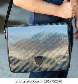 Young Man Holding A Gray Shiny Messenger Sport Bag Close Up