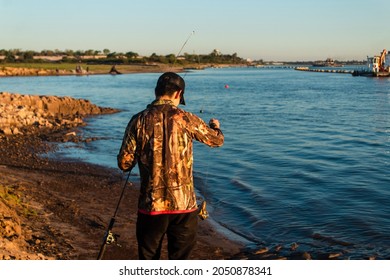 Young Man Holding His Fishing Rod With A Small Fish.