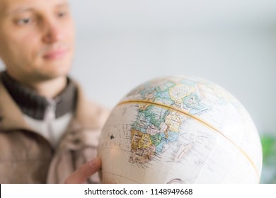 Young Man Holding Looking At Vintage Retro Old Brown Globe World Map With Equator, Africa Continent