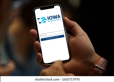 Young Man Holding A Phone Displaying The Democratic Party App Used In The Iowa Caucus Prior To The 2020 Presidential Election