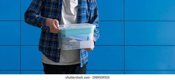 Young Man Holding A Plastic Box Container With Things Stored Inside