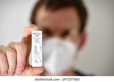 Young Man Holding Rapid Antigen Self Test For At Home With Negative Outcome Background Blurred