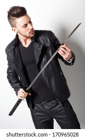 Young man holding a samurai sword.Fashion colors.