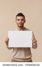 Young Man Holding Sign In Studio