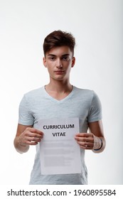 Young Man Holding Up A Sign With Text - Curriculum Vitae - To His Chest In A Concept Of Qualifications And Training For Job Seeking And Employment Isolated On White