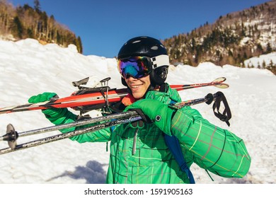 Young Man Holding Ski, He Looking Away And Smiling.