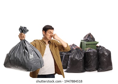 Young Man Holding A Smelly Bin Bag In Front Of A Waste Bin Isolated On White Background