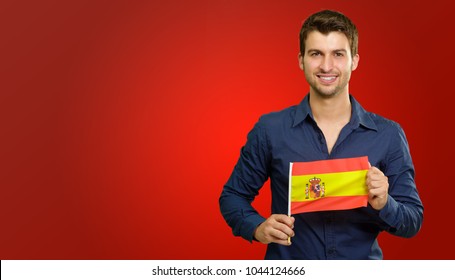 Young Man Holding Spain Flag Isolated On Red Background