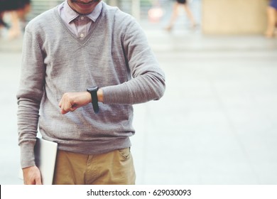 The Young Man Holding Tablet Stand Wait Looking Forward To Watching The Clock.