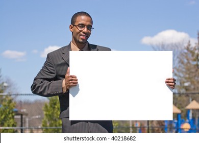 A Young Man Holds Up A Blank White Sign With Copyspace.