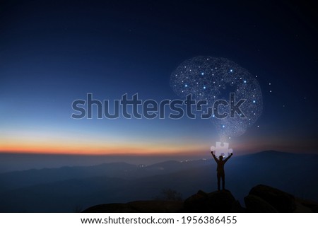 The young man holds a piece of the puzzle for completing all the information in his brain, creating an idea against an atmospheric background, Concept of idea and innovation. Stock photo © 