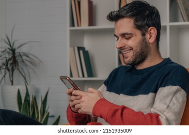 young man at home looking at mobile phone
