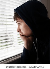 Young Man in a Hoodie by the Window in the Room closeup - Shutterstock ID 2393500413