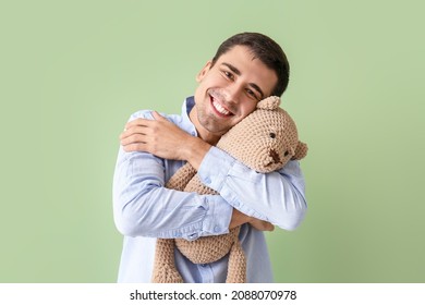 Joven abrazando oso de peluche con fondo de color