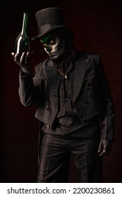 A young man in image of Baron Samedi, the Voodoo deity. Baron Saturday in black suit and top hat with a bottle of alcohol in hand. Day of the Dead (and Halloween) theme - Shutterstock ID 2200230861