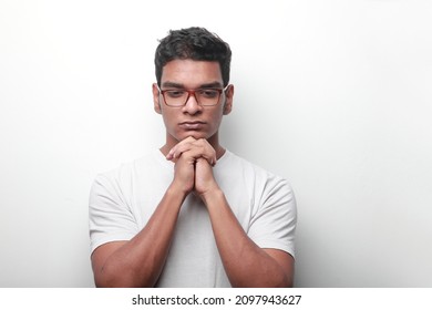 Young Man Of Indian Ethnicity Looking Down With Thoughtful Expression