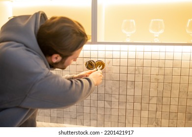 Young Man Installing The Wall Outlet In The Kitchen