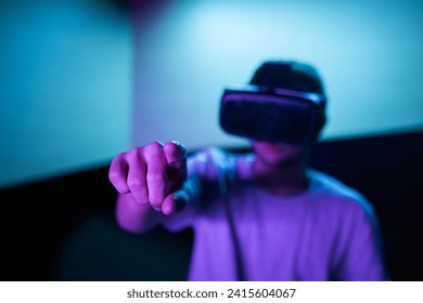 Young man interacting in a digital world, using virtual reality headset with motion tracking tech, making hand gestures in the air. - Powered by Shutterstock