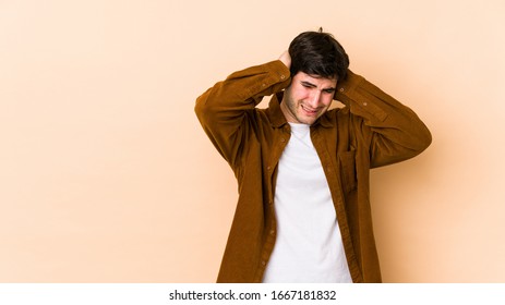 Young man isolated on beige background covering ears with hands. - Shutterstock ID 1667181832