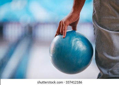 Young Man In Jeans Holding Bowling Ball