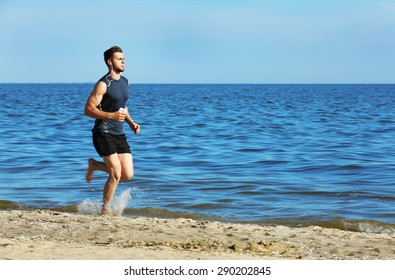 Young Man Jogging On Beach