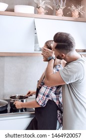 Young Man Joking With His Wife In The Kitchen