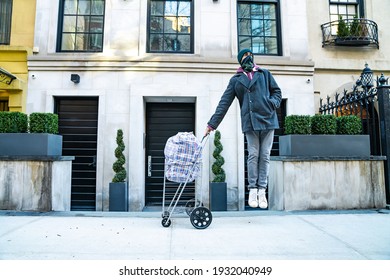 Young Man Jumping In The Air Holding Cart With Large Bazar Bag. The Thrift Shop, Charity, Cleaning Space, Moving, Donation Concept. Wearing Face Mask. Outdoors