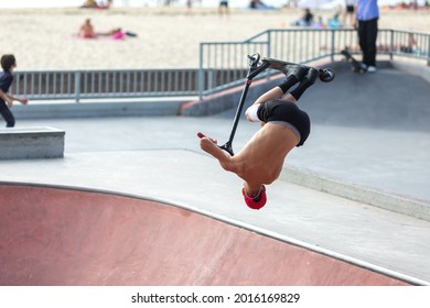 young man jumping on a scooter in a skatepak