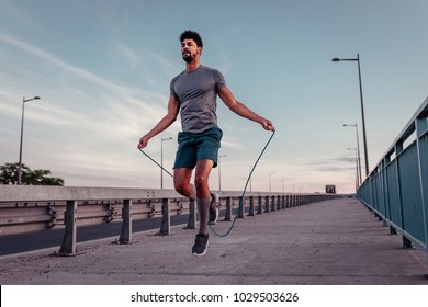 Young man jumping rope outside - Powered by Shutterstock