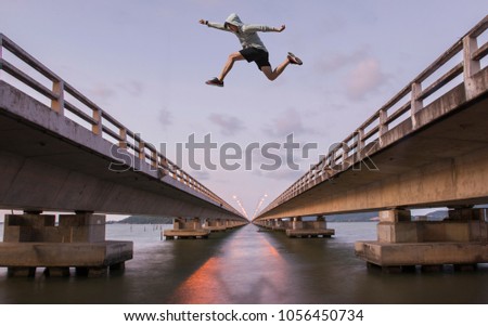 A young man jumps from a bridge. To the other side of the bridge.