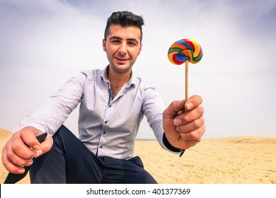 Young Man Kidnapper With Evil Face Offering Lollipop To Children On Secluded Beach - Handsome Parent Giving Lollies To Little Kid - Concept Of Pedophilia And Kidnapping Danger To Children Left Alone