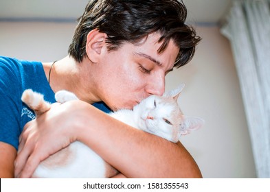 Young Man Kissing Cat Pet,holding In His Arms