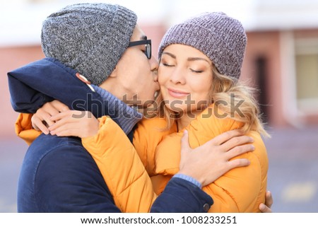 Young man kissing his beloved girlfriend outdoors