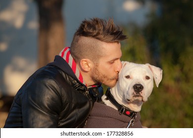 Young Man Kissing His Dog With Love 