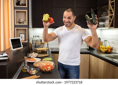 Young Man In The Kitchen Holding Vegetables Being Happy For He Is About To Prepare A Meal, Plant Based Diet Concept