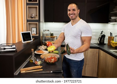 Young Man In The Kitchen Holding Vegetables Being Happy For He Is About To Prepare A Meal, Plant Based Diet Concept