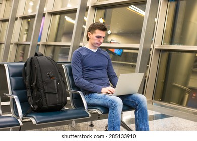 Young Man With Laptop And Backpack At Airport 