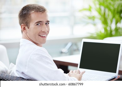 A Young Man With A Laptop In A Cafe